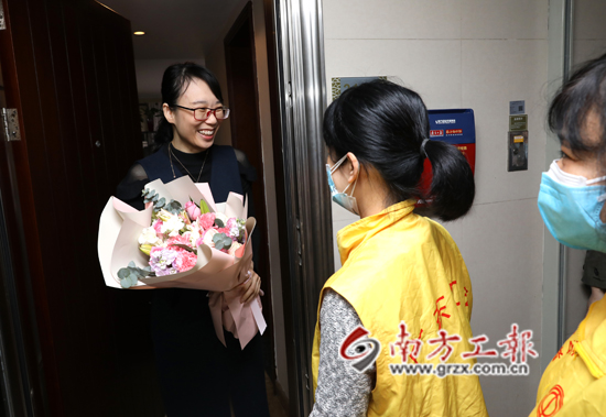 援鄂医生谢东平的妻子一大早就收到工会志愿者送上的鲜花,笑得很开心 林景余摄.JPG